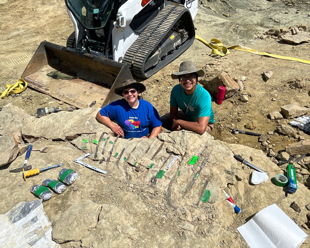Members of our paleo team with the Allosaurus fossil at the Jurassic Mile dig site in Wyoming.